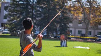 Student throws an atlatl