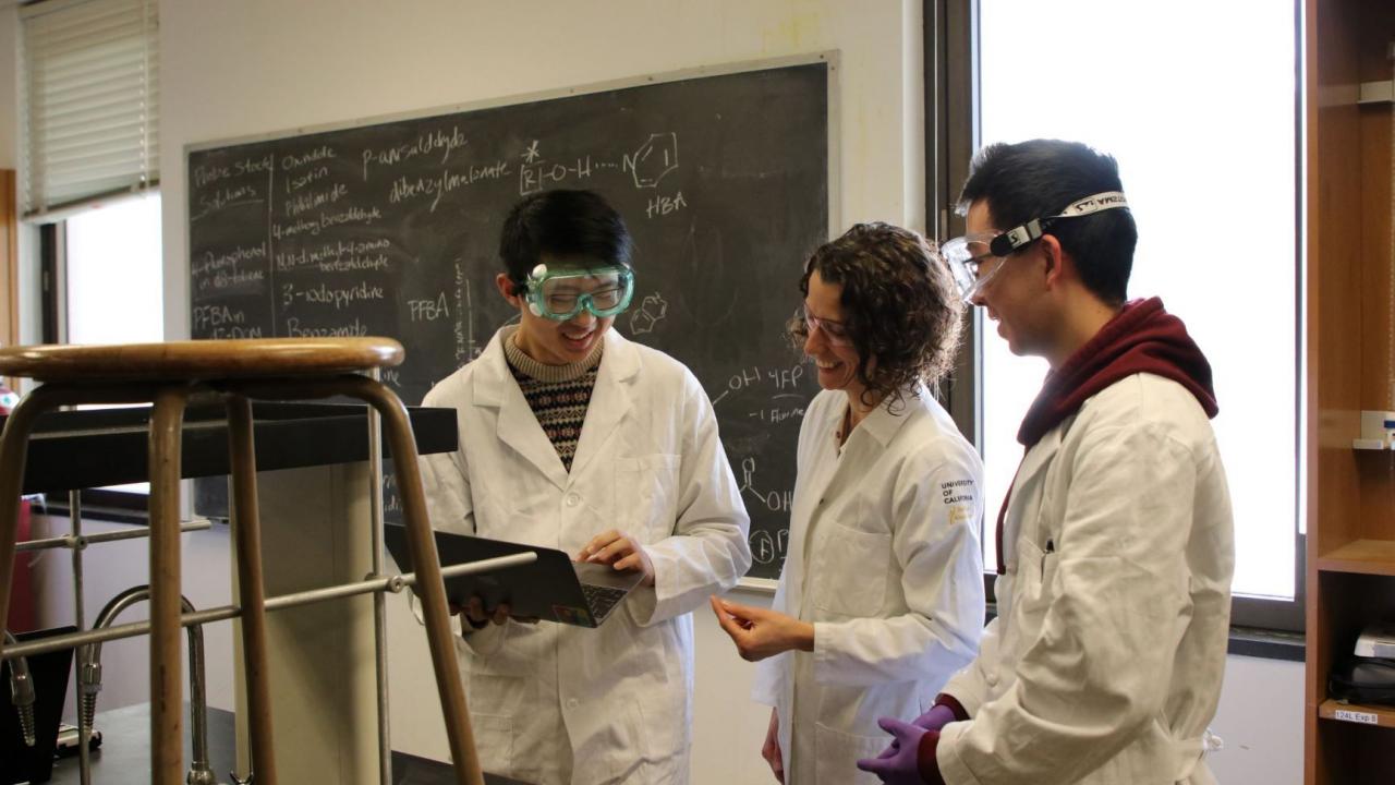 3 Researchers wearing lab coats in a CURE laboratory