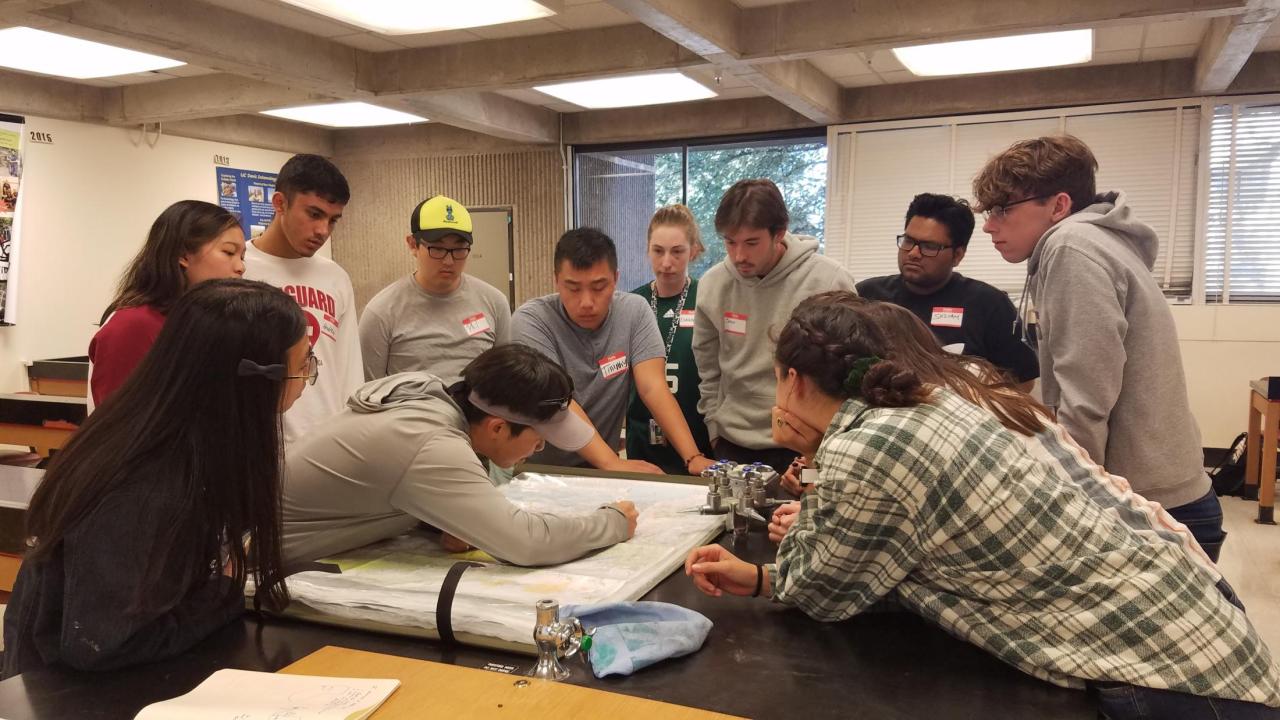 FYS students gathered around Dr. Yang viewing a map