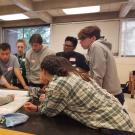 FYS students gathered around Dr. Yang viewing a map