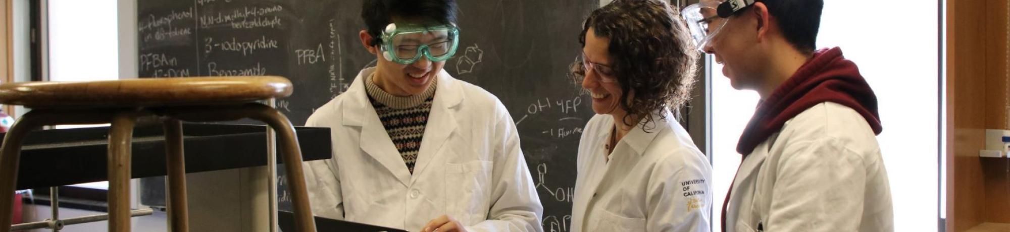 3 Researchers wearing lab coats in a CURE laboratory