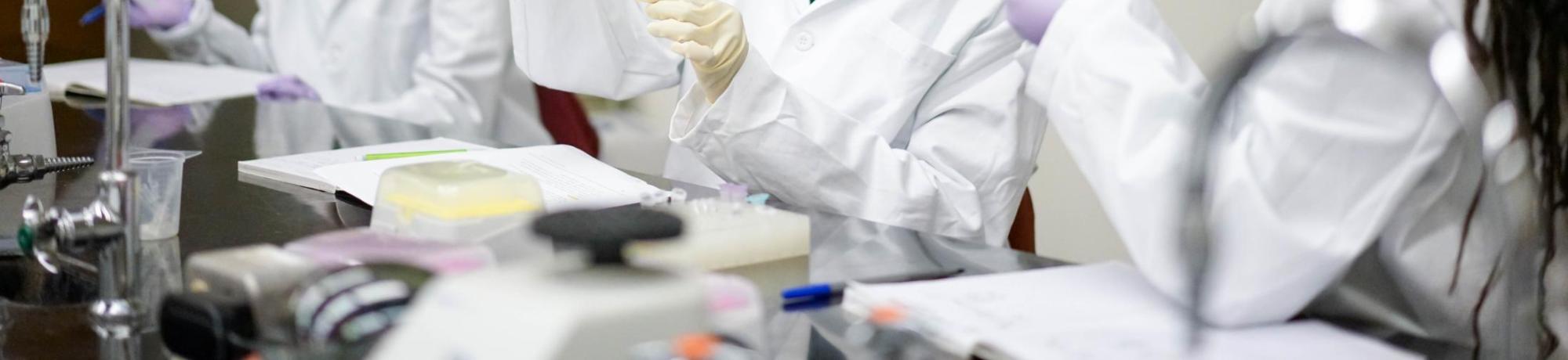  Students in white lab coats doing research