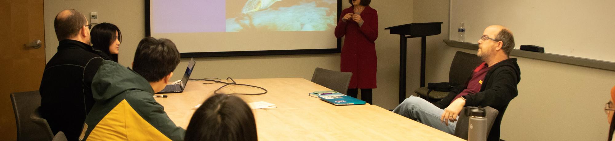 Instructor presenting projected slides in front of students